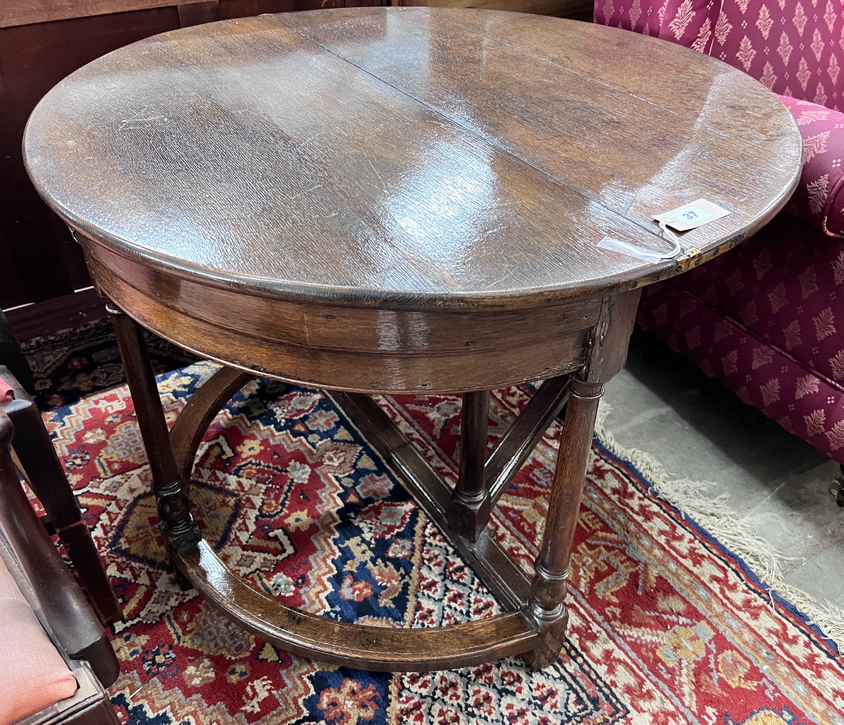 A late 17th century oak D shape folding tea table, diameter 94cm, height 70cm *Please note the sale commences at 9am.